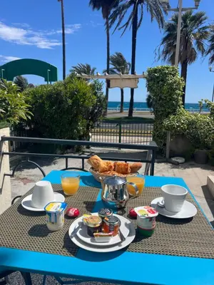 a breakfast table with a view of the beach at Hotel Flots d'Azur Promenade des Anglais in Nice