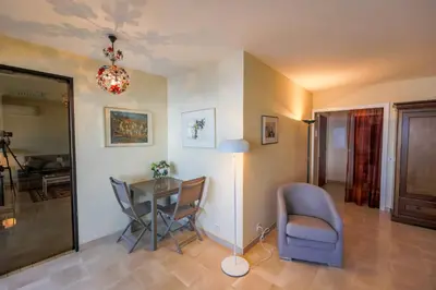 a living room with a table and chairs and a lamp at RESIDENCE DU CAP AP2027 - Villefranche-sur-Mer, by Riviera Holiday Homes in Villefranche-sur-Mer