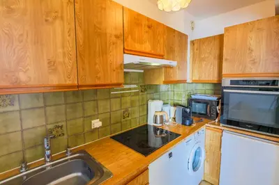 a kitchen with wooden cabinets and a sink and a microwave at RESIDENCE DU CAP AP2027 - Villefranche-sur-Mer, by Riviera Holiday Homes in Villefranche-sur-Mer