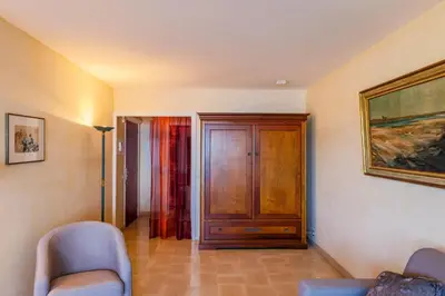 a room with two chairs and a wooden door at RESIDENCE DU CAP AP2027 - Villefranche-sur-Mer, by Riviera Holiday Homes in Villefranche-sur-Mer