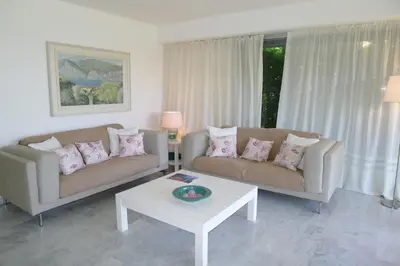 a living room with two couches and a coffee table at Jardin Figuiers AP4123 by Riviera Holiday Homes in Villefranche-sur-Mer