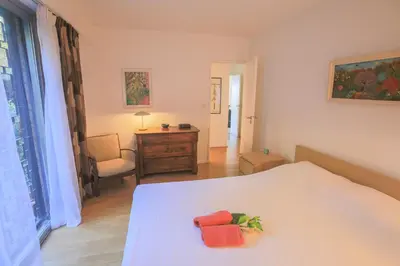 a bedroom with a bed with two orange towels on it at Jardin Figuiers AP4123 by Riviera Holiday Homes in Villefranche-sur-Mer