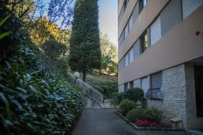 a hallway leading to a building with a tree next to it at Jardin Figuiers AP4123 by Riviera Holiday Homes in Villefranche-sur-Mer