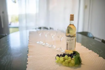 a bottle of wine and wine glasses on a table at Jardin Figuiers AP4123 by Riviera Holiday Homes in Villefranche-sur-Mer
