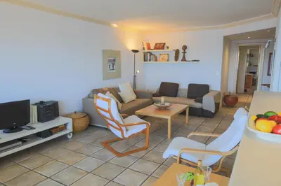 a living room with a couch and a table at Jardin Figuiers AP4123 by Riviera Holiday Homes in Villefranche-sur-Mer
