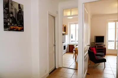 a hallway with a living room with a red chair at LIBERATION - Nice in Nice