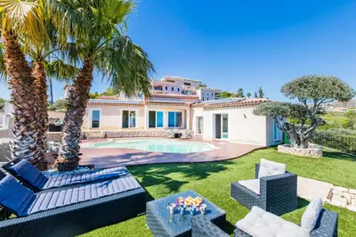 a villa with a swimming pool and palm trees at CORNICHE D'ARGENT - Nice in Nice