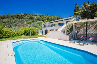 a swimming pool with two chairs and a house at Vinaigrier Hills VI3086 by Riviera Holiday Homes in Nice