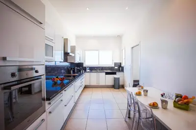 a large kitchen with white cabinets and a counter top at Vinaigrier Hills VI3086 by Riviera Holiday Homes in Nice