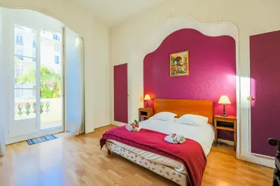 a bedroom with a large bed with a purple wall at VIA ITALIA AP1054 - By Riviera Holiday Homes in Nice