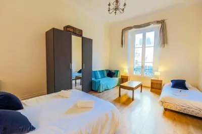 a bedroom with two beds and a mirror and a chair at VIA ITALIA AP1054 - By Riviera Holiday Homes in Nice