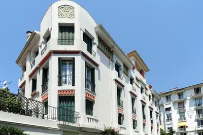 a white building with a clock on top of it at Suite ST Geneviève Five stars holiday house in Nice