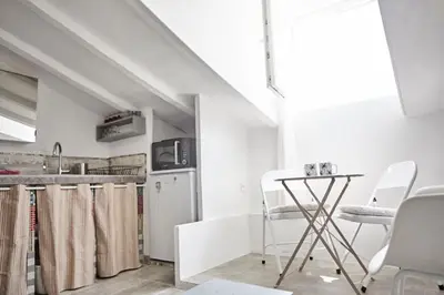 a kitchen with white appliances and a table and chairs at Studio Côte Blanche - Welkeys in Nice