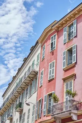 a brightly colored building with windows and balconies at Studio Côte Blanche - Welkeys in Nice