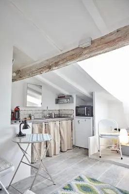 an attic kitchen with a table and a chair at Studio Côte Blanche - Welkeys in Nice