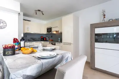 a kitchen with a table with a white table cloth at JARDINS MASSENA AP4088 Nice, by Riviera Holiday Homes in Nice