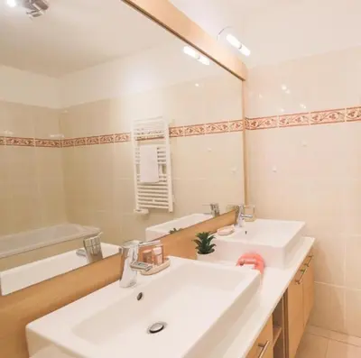 a bathroom with two sinks and a large mirror at JARDINS MASSENA AP4088 Nice, by Riviera Holiday Homes in Nice