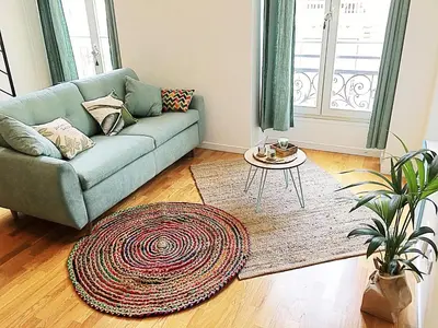 a living room with a couch and a rug at Homelivia, Appart FRIDA, mezzanine, déco raffinée et balcon in Nice
