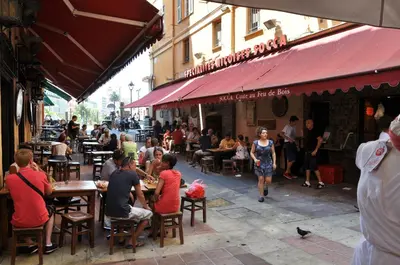 a group of people sitting at tables outside a restaurant at Charmant studio tout proche du port in Nice