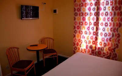 a room with a table and chairs and a curtain at Hotel Arc En Ciel in Èze