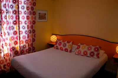 a bedroom with a bed with two pillows and a window at Hotel Arc En Ciel in Èze