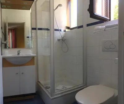 a bathroom with a shower and a toilet and a sink at Hotel Arc En Ciel in Èze