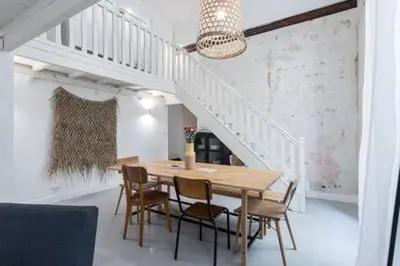 a dining room with a table and chairs and a staircase at Prefecture Duplex - Old Town in Nice