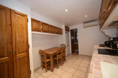 a kitchen with a wooden table and chairs in it at La Plenitude in Cagnes-sur-Mer