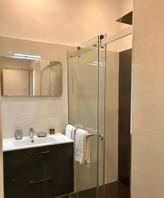 a bathroom with a sink and a glass shower at Hotel Cresp in Nice