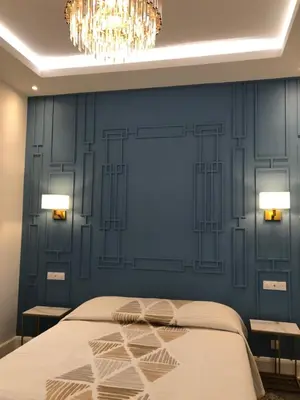 a bedroom with a blue wall with a bed and two tables at Hotel Cresp in Nice