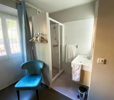 a bathroom with a blue chair and a sink at Hôtel La Villa d'Eze in Èze
