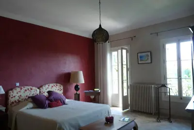 a bedroom with a bed and a red wall at Castel Enchanté in Nice