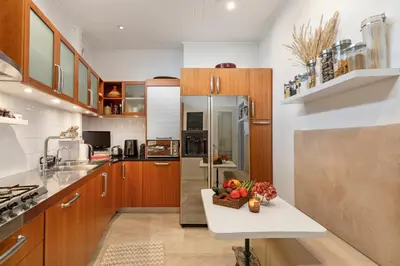 a kitchen with wooden cabinets and a table with fruit on it at Unique sea view apartment, center, 100m2 in Nice