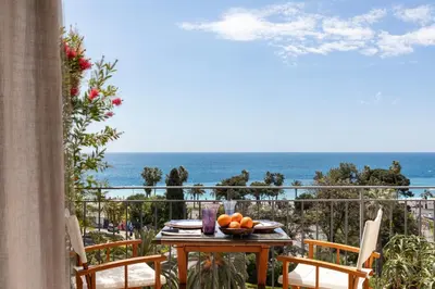a table with a bowl of oranges on a balcony with the ocean at Unique sea view apartment, center, 100m2 in Nice