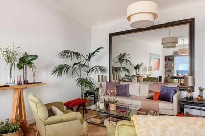 a living room with a couch and a mirror at Unique sea view apartment, center, 100m2 in Nice