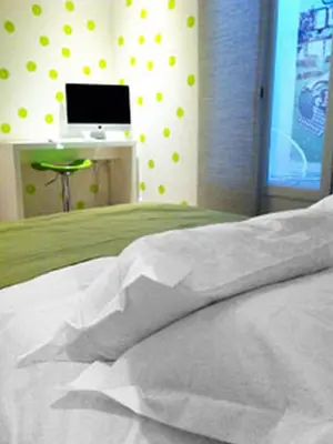 a bedroom with a white bed and a computer monitor at Little Palace in Nice
