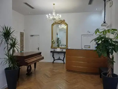 a mirror and a piano in a room with plants at Little Palace in Nice