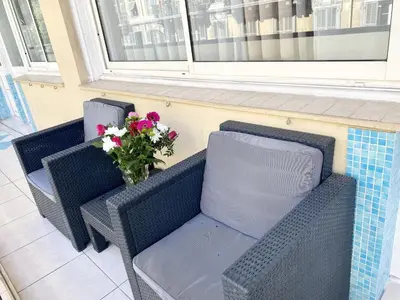 two wicker chairs and a vase of flowers on a porch at NOTRE DAME - Huge sunny modern 2BR flat - Terrace in Nice