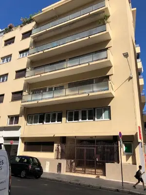 a building on a street with a person walking past it at NOTRE DAME - Huge sunny modern 2BR flat - Terrace in Nice