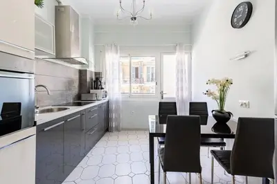 a white kitchen with a dining table and chairs at NOTRE DAME - Huge sunny modern 2BR flat - Terrace in Nice