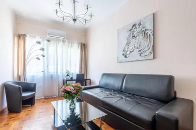 a living room with a black leather couch and a table at NOTRE DAME - Huge sunny modern 2BR flat - Terrace in Nice