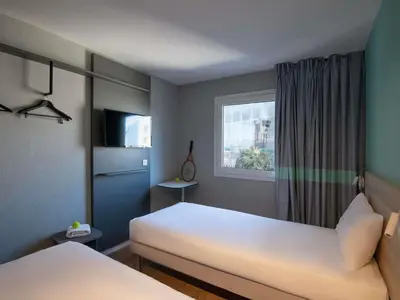 a bedroom with a large white bed and a window at ibis budget Nice Aeroport in Nice
