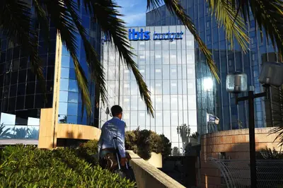 a man walking in front of a building with the tbs energy sign at ibis budget Nice Aeroport in Nice