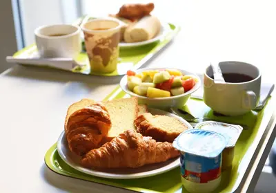 a tray with two plates of pastries and bread and coffee at ibis budget Nice Aeroport in Nice