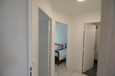 a white room with a bed and a mirror at PLEIN CIEL - Appartement 5 personnes avec piscine sur la Corniche Fleurie à Nice in Nice
