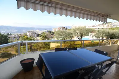a blue table and chairs on a balcony with a view at PLEIN CIEL - Appartement 5 personnes avec piscine sur la Corniche Fleurie à Nice in Nice