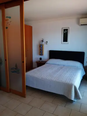 a bedroom with a bed and a tv and a door at The Dina Palace. in Villefranche-sur-Mer