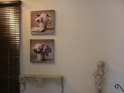 three pictures of flowers in vases on a wall at La Suite du Village d'Eze in Èze