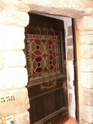 a black door with a metal gate in a stone wall at La Suite du Village d'Eze in Èze
