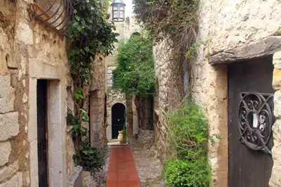 an alley in an old stone building with a door at La Suite du Village d'Eze in Èze